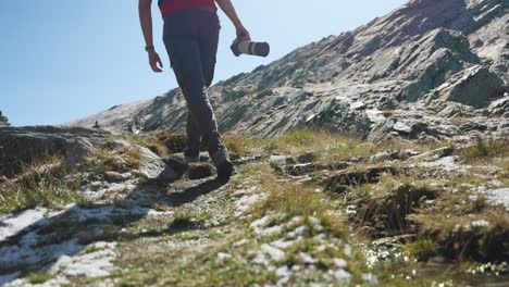 Low-angle-shot-of-photographer-walking-through-mountain-with-melting-fresh-snow