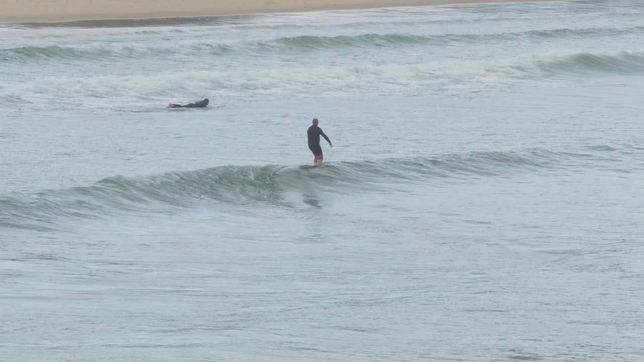 바다 파도에 의해 움직이는 서핑 보드에 서있는 남성 서퍼 - scotts head, nsw, australia에서 서핑