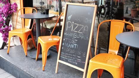 cafe with orange chairs and a chalkboard menu