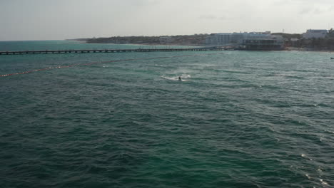 Luftbild-Mit-Zwei-Männchen,-Die-Mit-Jetski-Auf-Den-Wellen-Auf-Dem-Karibischen-Meer-Reiten.-Der-Strand-Von-Playa-Del-Carmen-Im-Hintergrund