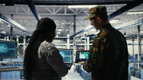 military commander and female programmer in data center tracking coordinates