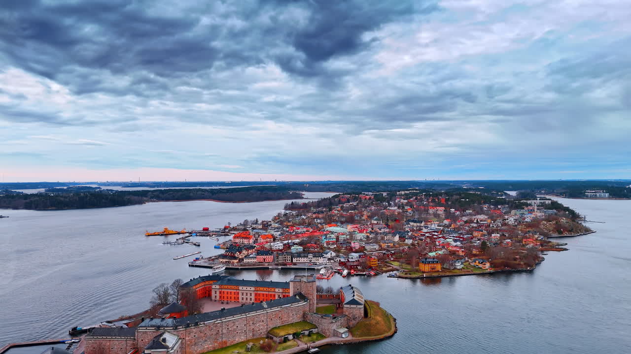 Aerial view of Vaxholm town center and historic island fortress. Bird's eye perspective of a coastal Swedish town featuring colorful buildings, harbor, and a stone castle