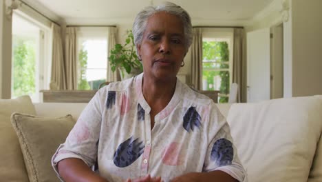 retrato de una mujer mayor afroamericana hablando mirando a la cámara en casa