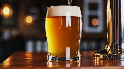 pouring beer into a glass at a bar