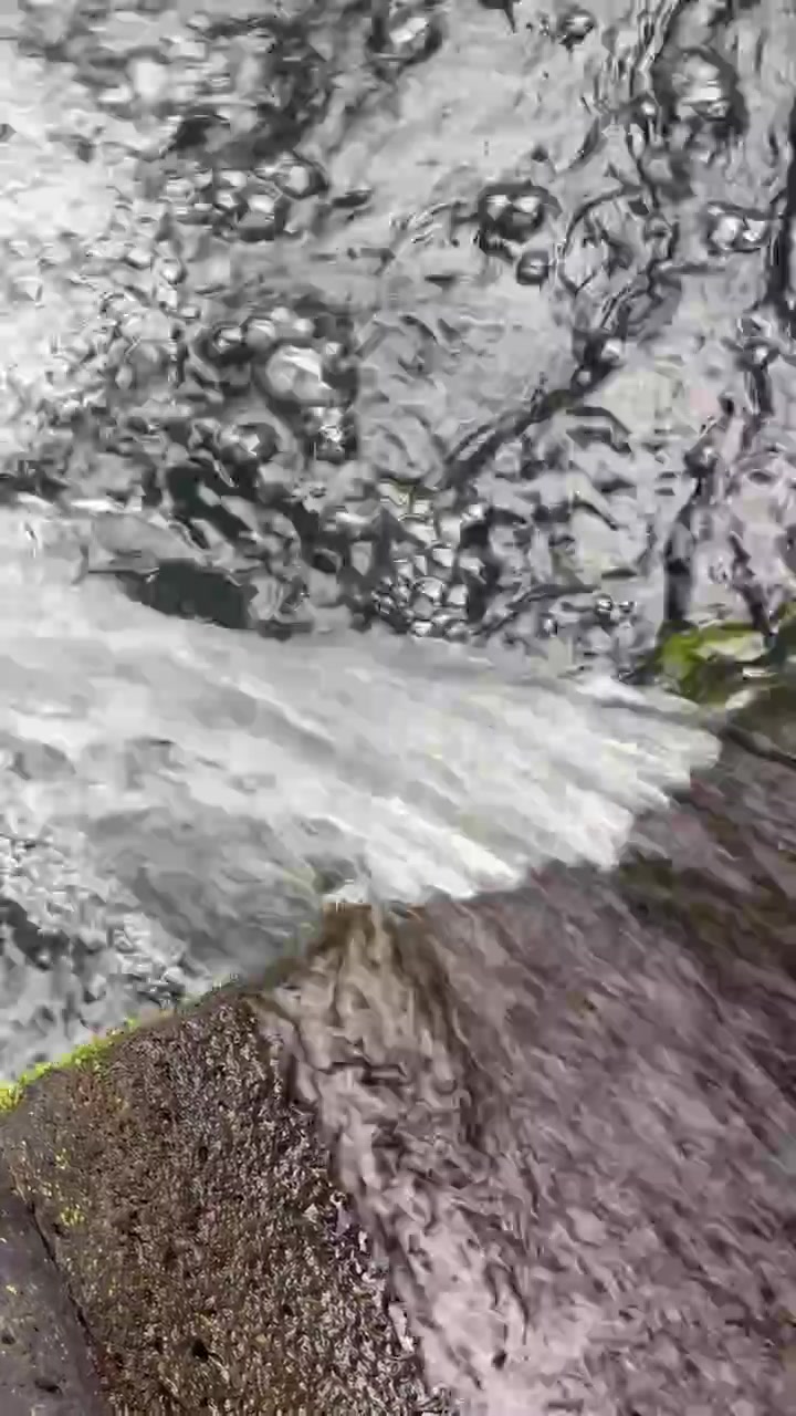 Agua fluyendo sobre el borde de una piedra en un arroyo