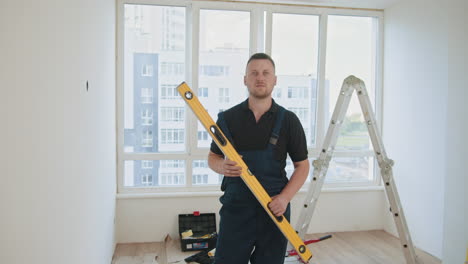 construction worker holding a level in a room under renovation