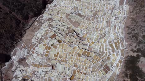 high angle establishing of the ancient salineras de maras salt pans cascading down the mountains