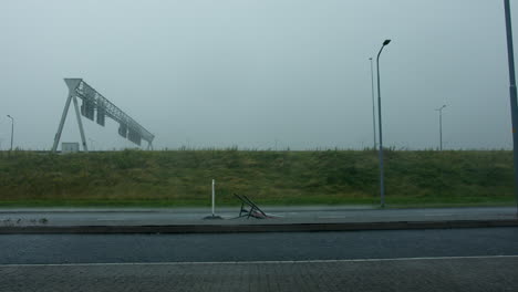 stormy weather on the highway: damaged roadside sign and flooded road