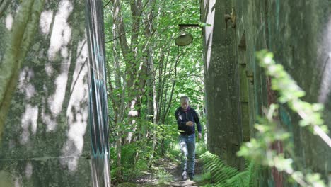 overgrown narrow path, weeds, derelict structure, elder male, slow motion