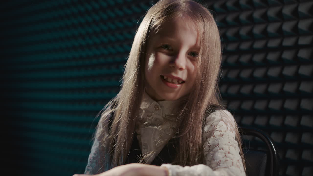 아이는 피아노로 음악의 언어를 표현합니다. 어린 소녀 아티스트는 디지털 악기 멜로디를 능숙하게 탐색하여 매혹적인 공연을 제공합니다. 예술적 헌신