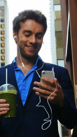 hombre de negocios hablando por teléfono móvil mientras toma jugo
