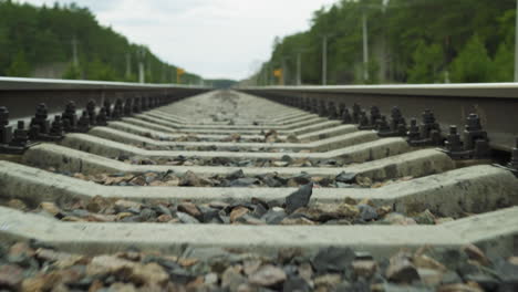 close-up slow view of a railway track focusing on the concrete sleepers and gravel ballast, with perspective leading towards the horizon