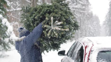 Man-with-senior-father-packing-Christmas-tree-on-the-car