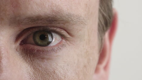 close up young caucasian man eye looking around isolated on white background