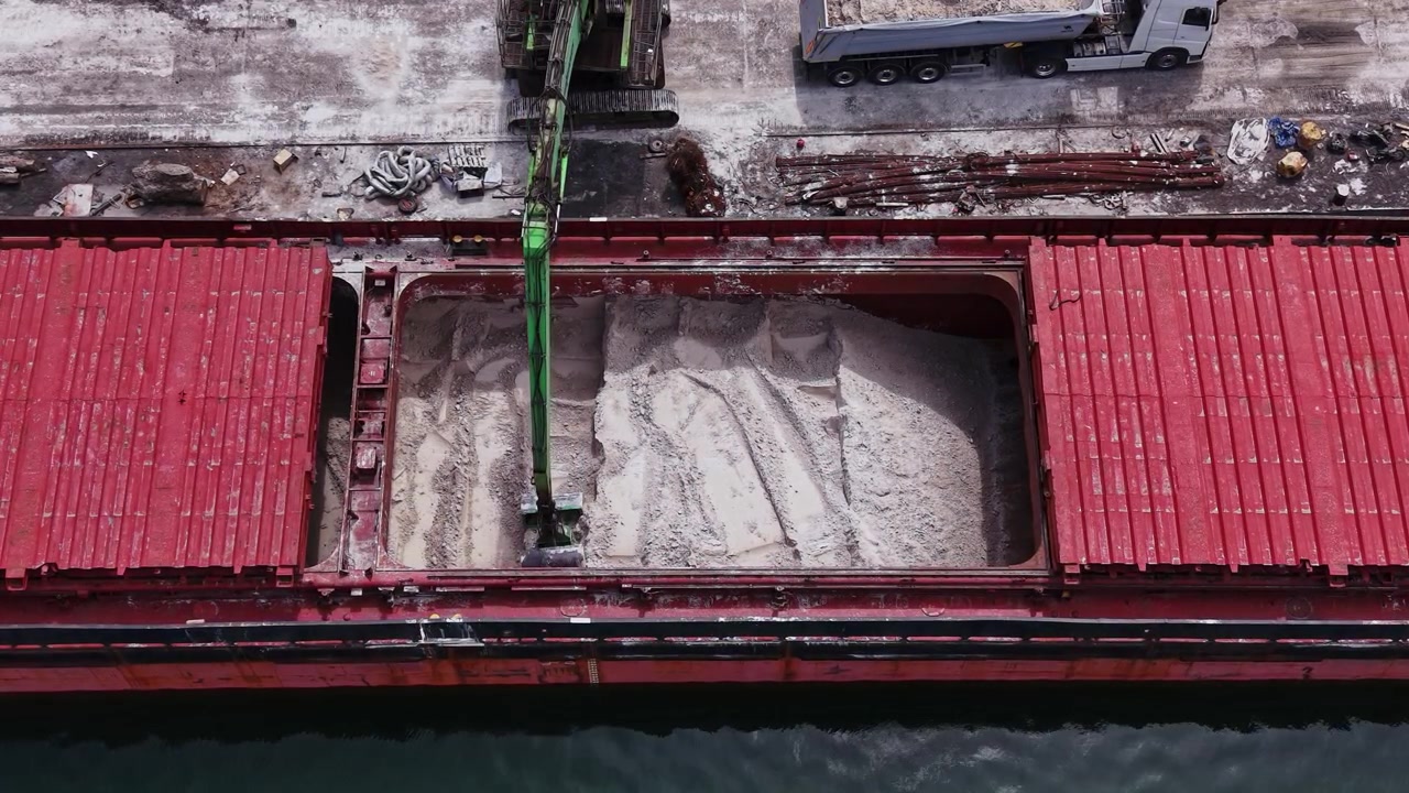 Grande nave da carico in fase di caricamento di materiali in un porto