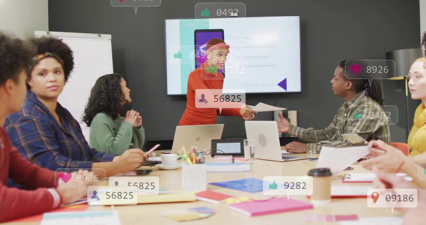 Presenter speaking and handing papers in business meeting, gesturing at monitor; icons moving