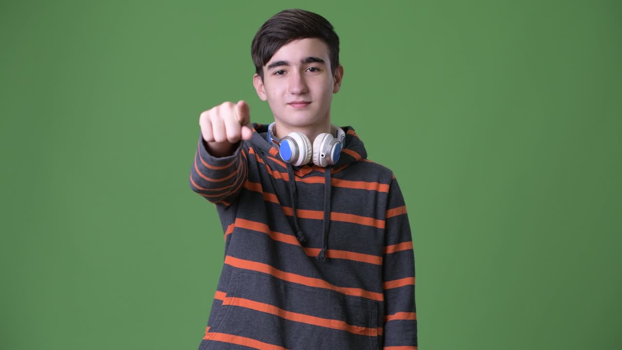 초록색 배경에 젊은 잘생긴 이란 십대 소년