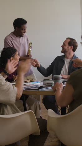 team celebrates an award and recognition at an office meeting