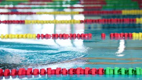 Powerful-female-swimmer-swimming-breaststroke-at-speed,-tracking-shot