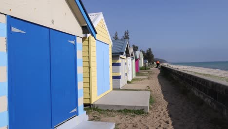 beach boxes along a sandy path in melbourne