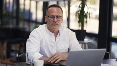 Hombre-De-Negocios-Sonriente-Trabajando-En-Una-Computadora-Portátil-Mientras-Toma-Un-Café.-Retrato-De-Un-Hombre-De-Negocios-Positivo-Mirando-La-Pantalla-Del-Portátil-En-El-Interior