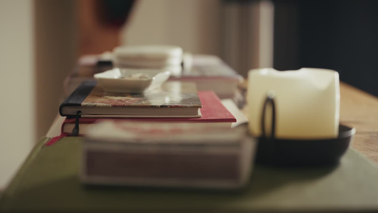 Smartphone on books with candlelit ambiance, conveying calm and focus