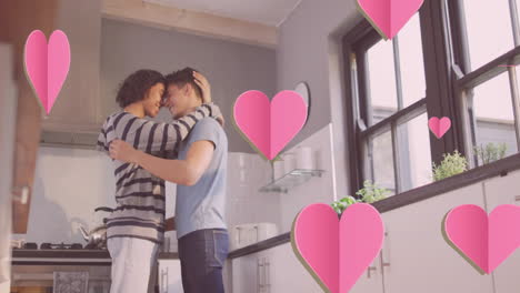 Animación-De-Corazones-Rosados-Sobre-Una-Feliz-Y-Diversa-Pareja-De-Hombres-Gay-Abrazándose-En-La-Cocina.