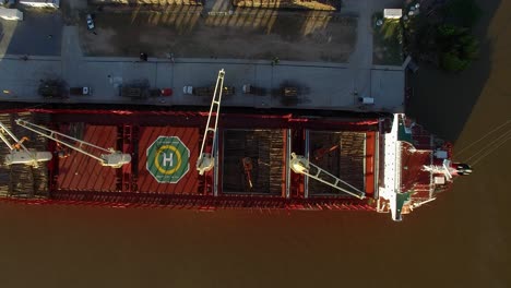vista superior del buque de carga con helipuerto y grúas cargando maderas en el puerto de buenos aires en argentina
