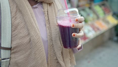 woman drinking juice in a market