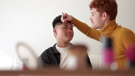 man applying eye makeup to another person