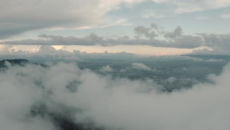 beautiful landscape drone aerial shot, flying over clouds, top of the mountain in a cloud forest