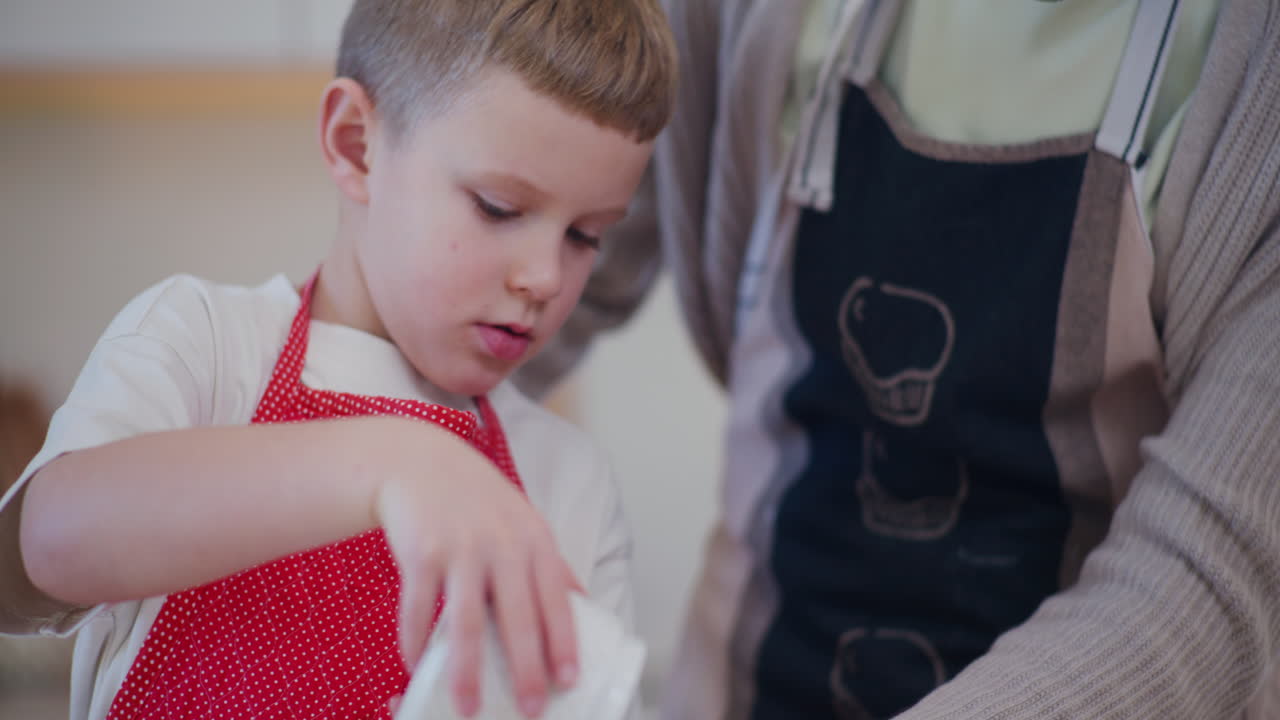 niño derrama azúcar en el vidrio mientras hornea galletas