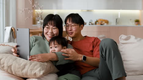 happy asian family watching tablet together