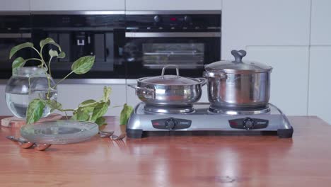 Portable-electric-Stove-with-Hand-Placing-Saucepan-on-Plate