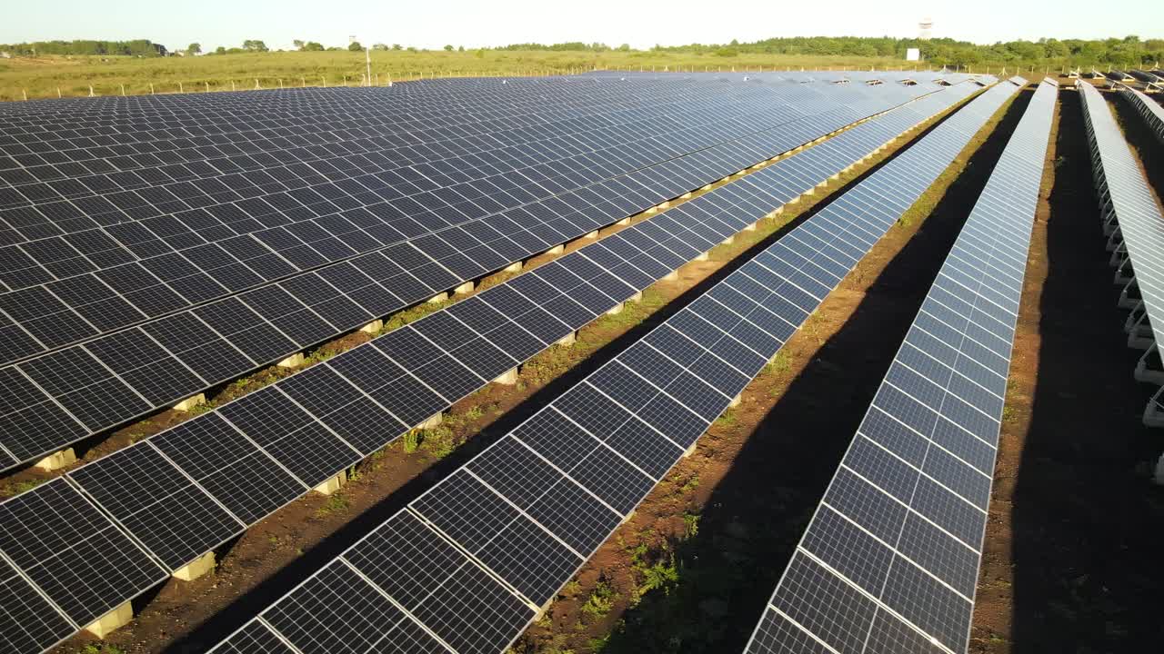 Luftfoto over rækker af grønne solcellefelter, der producerer ren alternativ elektrisk energi