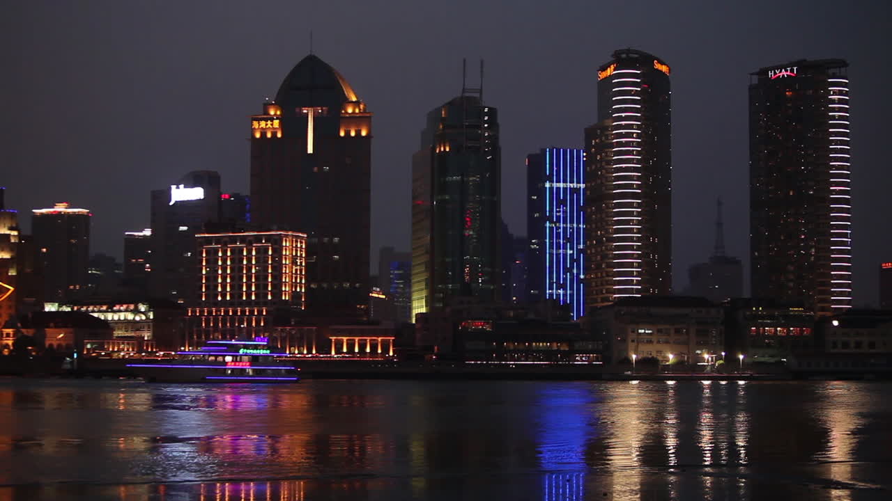 el horizonte nocturno de shanghai china con el tráfico fluvial en primer plano y un barco alto iluminado que pasa 3
