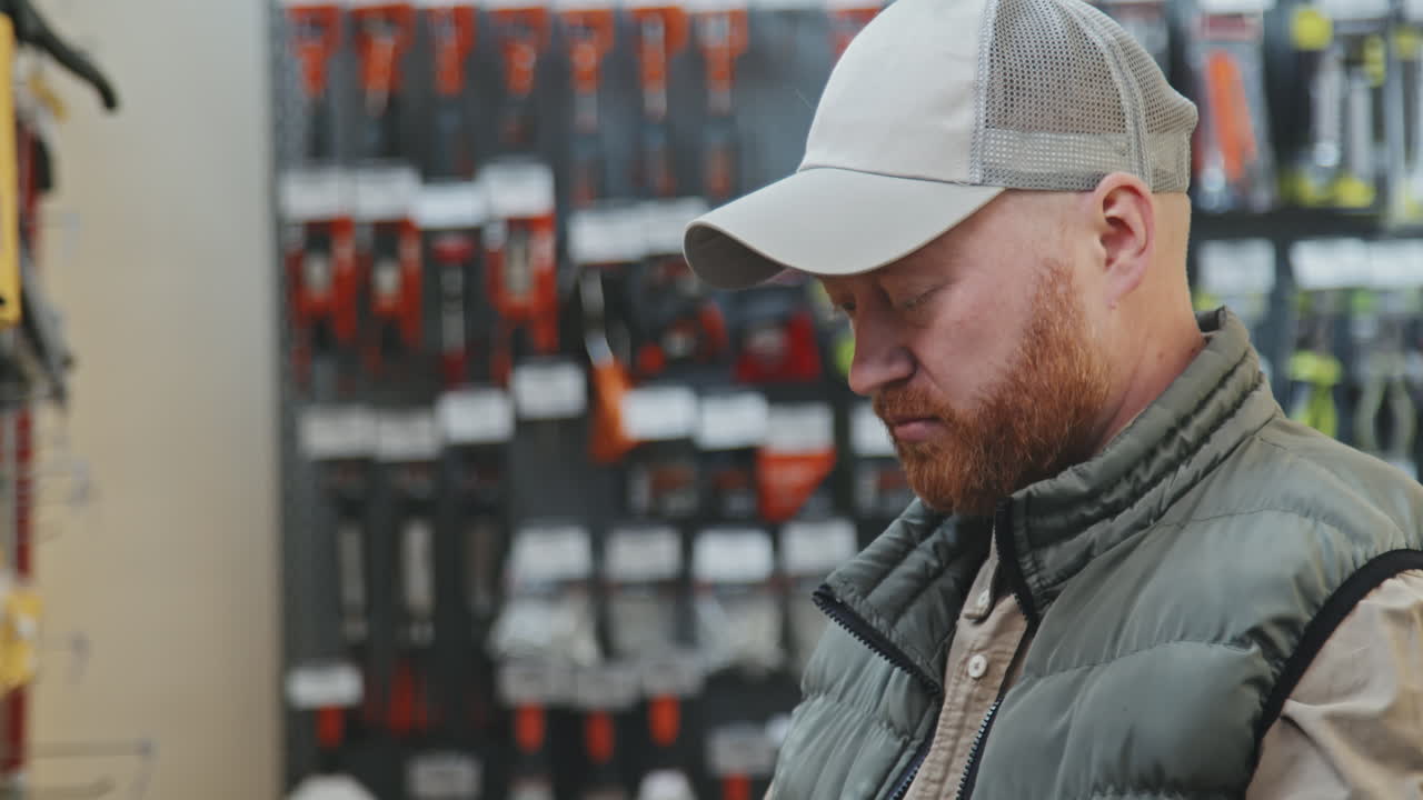 Bearded Man Choosing Product at Hardware Store