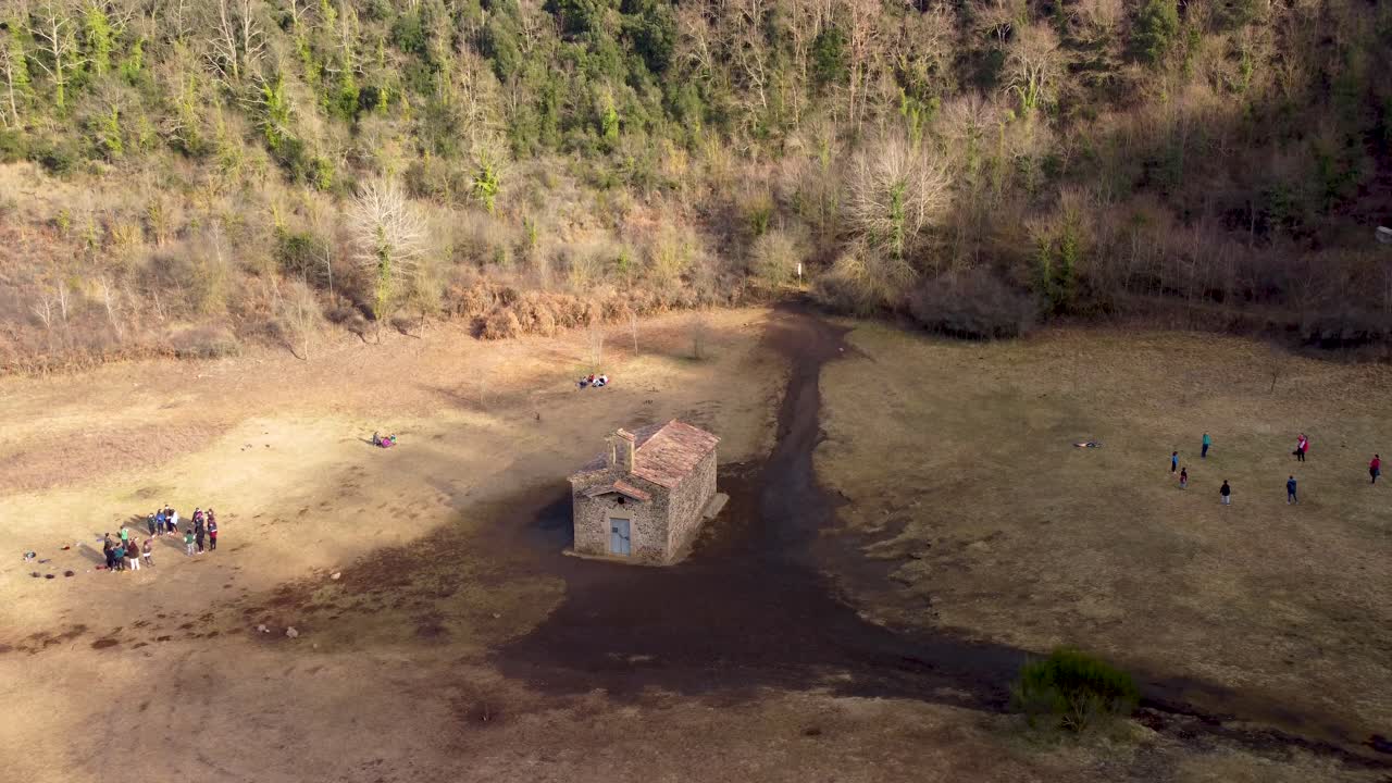 Volo in alto di drone aereo che rivela il vulcano inattivo di Santa Margarida: cratere massiccio e cappella storica in Catalogna, Spagna