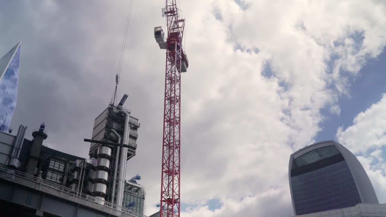 A crane is carrying a lift in a construction site during daytime in cloudy weather for a new building in city center