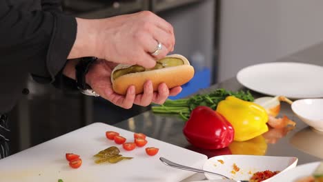 el chef preparando un perrito caliente