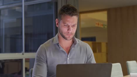 Businessman-working-on-laptop-in-a-modern-office