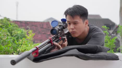 asian sniper flips up lens cap covers on scoped pcp air rifle looking and aiming