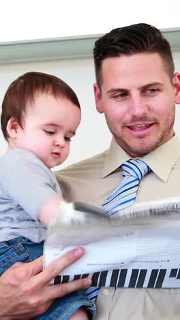 father carrying his baby son before work and talking on phone