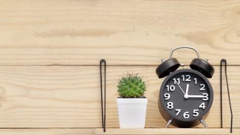 black watch and a baton in a white diamond pot placed on a shelf next to a wooden wall, showed that it was a break, start time 12:00 stop 12:15.