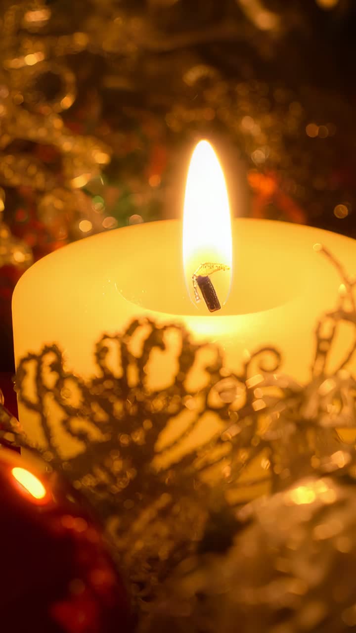 Vertical video: Flickering cream candle wobbling flame from drafts on table with wax-well lace-trim
