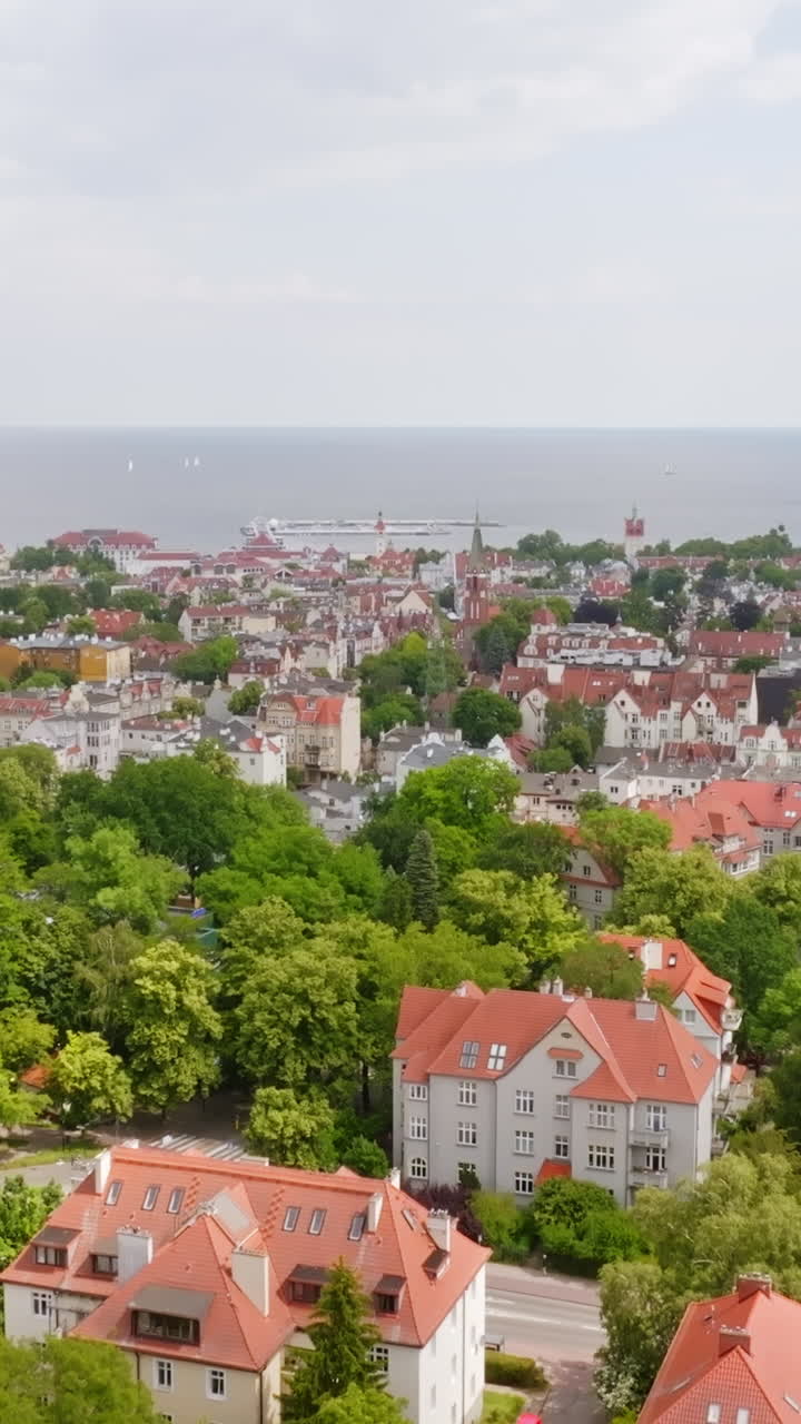 Ripresa aerea verticale con drone che si inclina di fronte allo skyline di Sopot, estate in Polonia