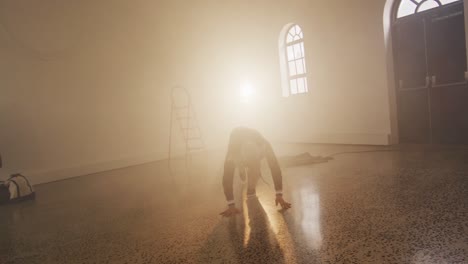 portrait of biracial male dancer dancing in dance studio, slow motion