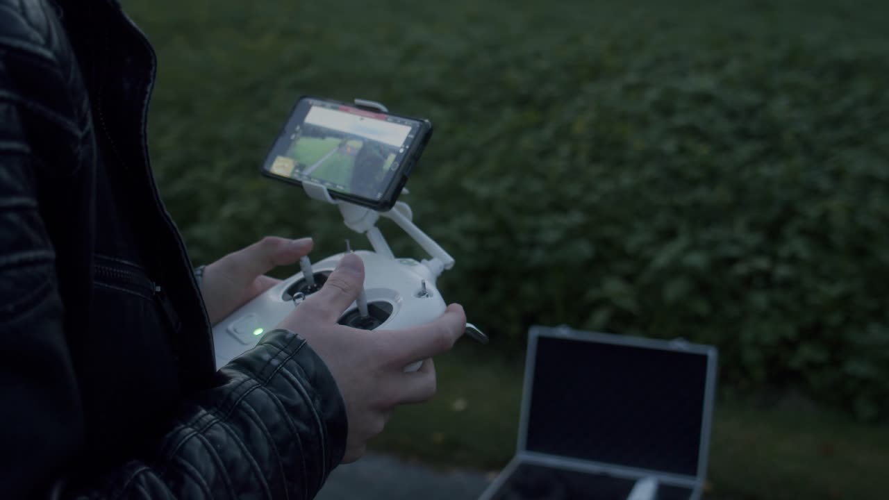 manos que controlan un dron a través de un controlador con pantalla