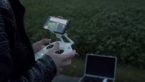 manos que controlan un dron a través de un controlador con pantalla
