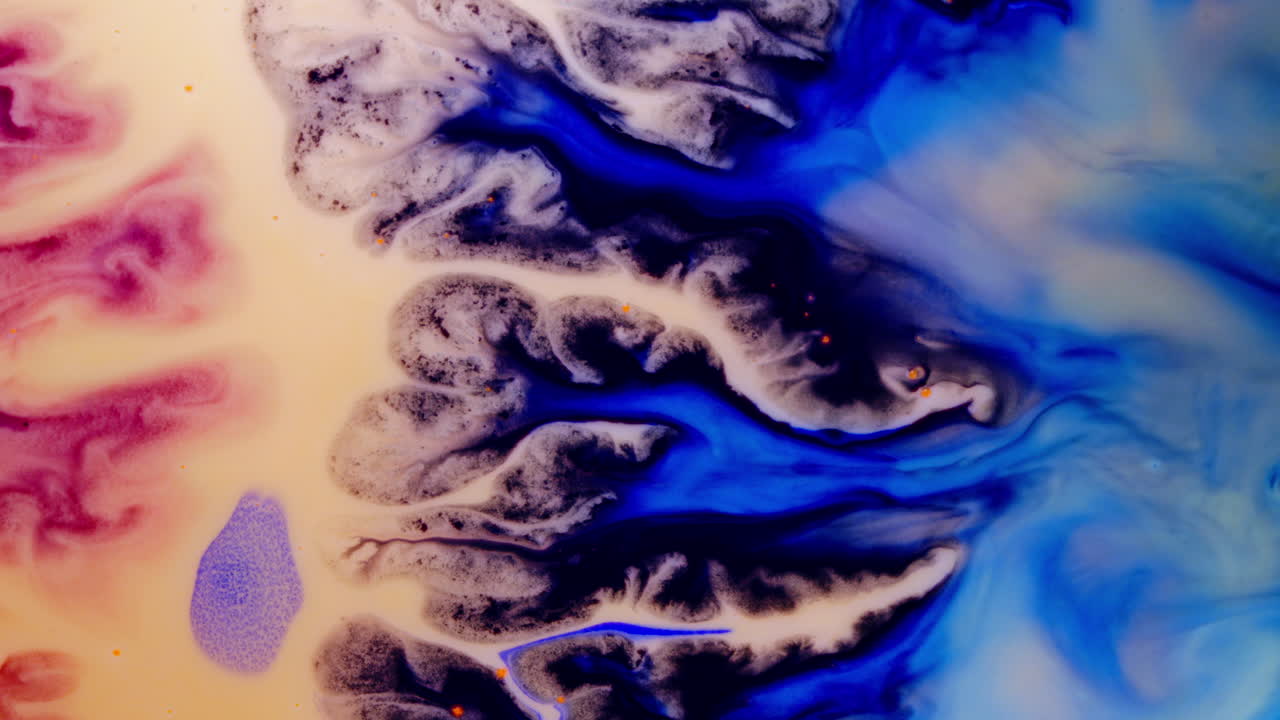 Substances mixing, close-up shot of colorful liquids blending together in an abstract display